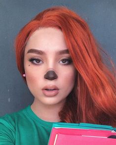 a woman with red hair and a fake nose holding a binder