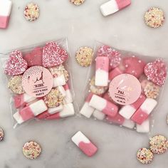 two bags filled with pink and white marshmallows on top of a table