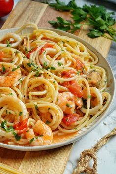 a plate of pasta with shrimp and tomatoes