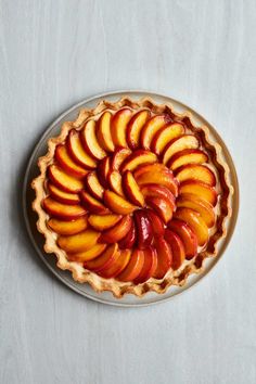 a pie with sliced peaches in it on a plate