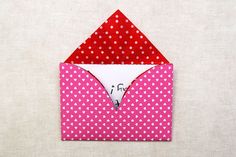 an envelope with a red and white polka dot pattern is opened to show the inside