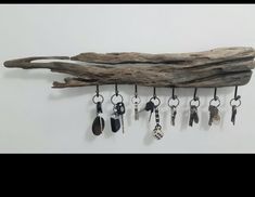 a piece of driftwood with key chains hanging from it's sides and several other keys attached to the hooks