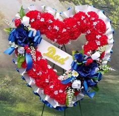 a heart shaped wreath with the number twenty one on it and flowers in front of trees