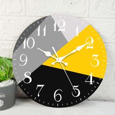 a clock that is sitting next to a potted plant