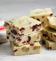 several pieces of white chocolate with cranberry toppings stacked on top of each other