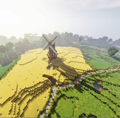 an aerial view of a yellow field with a windmill