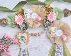 some flowers and ribbons on a table with other items in the background that include brooches