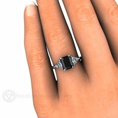 a woman's hand with a black and white diamond ring on top of it