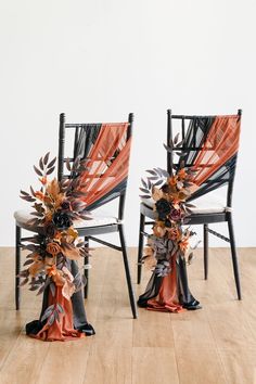 two chairs decorated with flowers and ribbons on top of a wooden floor in front of a white wall