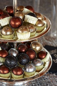 two tiered trays filled with cupcakes on top of a table