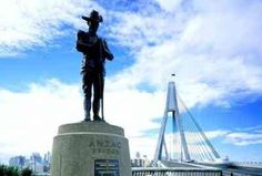 a statue stands in front of a bridge