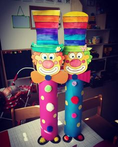 two clowns made out of toilet paper on top of a table in a room