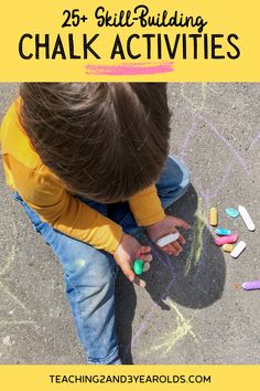 a young boy sitting on the ground with chalk crayons