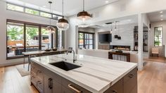 a large kitchen with an island in the middle and lots of windows on both sides