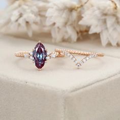 two engagement rings with an oval cut and pear shaped blue topaz surrounded by diamonds