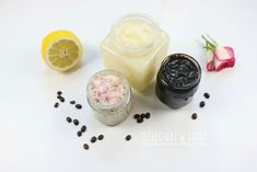 two jars filled with different types of food next to some flowers and lemon wedges