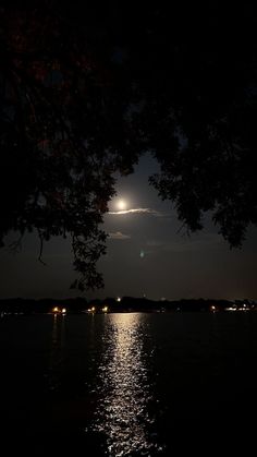 the moon is shining brightly over the water