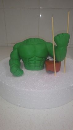 there is a cake that looks like a hulk - man with two sticks sticking out of it