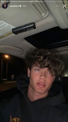 a young man sitting in the back seat of a car