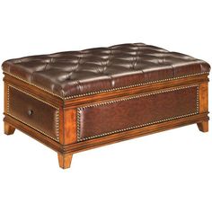 a brown leather ottoman sitting on top of a wooden table