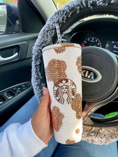 the starbucks cup has been decorated with gold glitters and is being held up by someone's hand