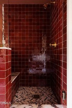 a bathroom with red tile walls and floor