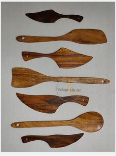 four wooden paddles are lined up on a table