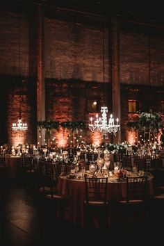 the tables are set with candles and centerpieces for an elegant wedding reception at night