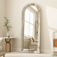 a living room with a couch, chair and large mirror in the middle of it