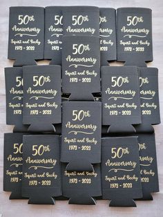 black and gold 50th anniversary napkins are laid out on a table with white writing