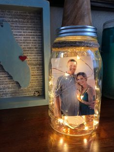 a mason jar filled with lights and an image of a man and woman