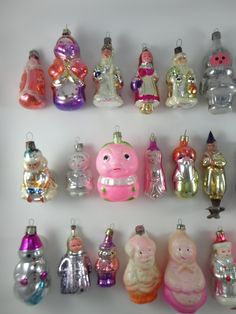 a collection of glass christmas ornament in various colors and sizes on a white surface