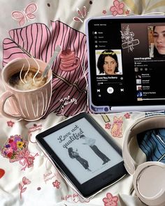 there is a tablet and headphones on the bed next to each other, with an image of a woman's face