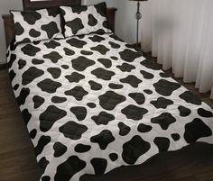 a black and white cow print comforter on a bed