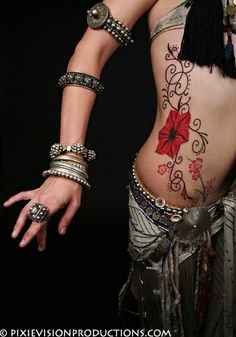 a woman with tattoos and bracelets on her stomach