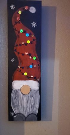 a painting of a santa hat with lights on it's head is hanging on the wall