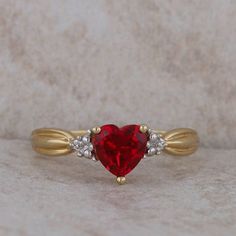 This ladies 10k yellow gold ring has a 6x6mm lab grown ruby in the center with two round diamonds on either side that equal .015ctw. The prongs on the sides make it look like there are three stones on either side. The shank is 1.5mm and the finger size is 6.75. The ring weighs 1.71 grams. Condition: Pre-Owned *All items are thoroughly inspected for quality assurance purposes Ruby And Diamond Ring, Yellow Gold Ring, Three Stone, Yellow Gold Rings, Rings Statement, Lab Grown, Gold Ring, Round Diamonds, Statement Rings