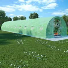 a large green building sitting on top of a lush green field