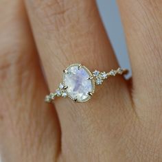 a woman's hand with a ring on it and a white stone in the middle