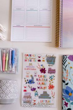 the contents of a planner spread out on a white surface with pens, markers and notebooks