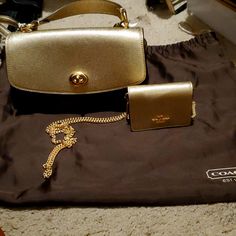 Set Brown And Gold Coach Bag And Chain Cross Body Luxury Gold Wallet On Chain With Branded Hardware, Classic Gold Shoulder Bag With Chain, Classic Gold Bag With Chain Detail, Gold Shoulder Bag With Chain For Travel, Gold Chain Shoulder Bag For Travel, Coach Luxury Wallet On Chain For Formal Occasions, Luxury Coach Wallet On Chain With Detachable Strap, Luxury Coach Wallet On Chain For Formal Occasions, Chic Gold Wallet On Chain With Branded Hardware