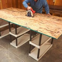 a man sanding down a wooden table with a circular sawhorse on the top