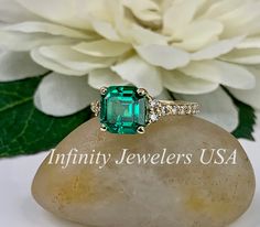 "https://www.instagram.com/p/B2UZuL_FDP6/?igshid=1nxbvto2och33 This ring is an asscher cut lab created green emerald with moissanite accents, 14k yellow gold #6189 Emerald is the birthstone of May -Approximate total carat weight: 2.55ctw diamond equivalent -Center Stone Size: approx. 2.20ct diamond equivalent -Center Stone Shape: asscher 8x8mm -Gem Type: lab created emerald -Stone Clarity: VS2 -Stone Color: lively medium green, eye-clean -Moh's Scale: 8.5 hardness -Accent Stones: 16 round -Accen Princess Cut Jewelry With Side Stones As Gift, Princess Cut Jewelry With Side Stones For Gift, Emerald Cut Jewelry With Side Stones For Anniversary, Asscher Cut Emerald Wedding Ring With Center Stone, Asscher Cut Moissanite Emerald Ring With Center Stone, Emerald Asscher Cut Jewelry With Accent Stones, Asscher Cut Emerald Jewelry With Accent Stones, Green Cubic Zirconia Asscher Cut Jewelry, Green Asscher Cut Cubic Zirconia Jewelry