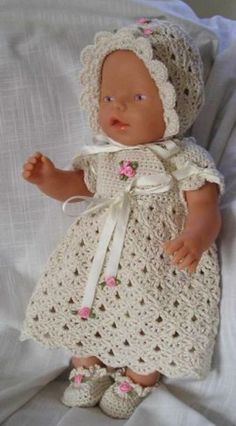 a baby doll wearing a white crochet dress and bonnet