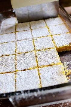 a pan filled with lemon bars on top of a wooden table