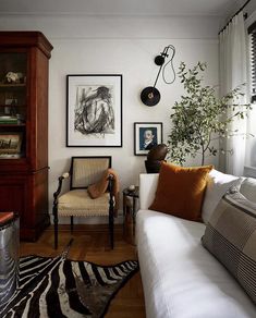 a living room filled with furniture and pictures on the wall