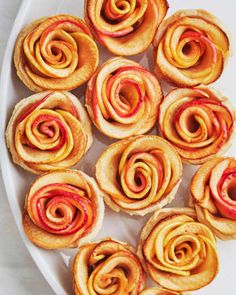 there are many small pastries on the white platter with red and yellow swirls