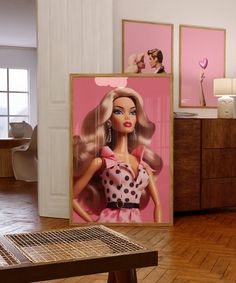 there is a barbie poster on the wall next to a coffee table and dresser in this room