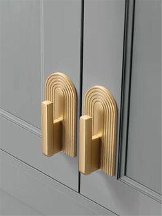 two gold handles on the front of a gray cabinet