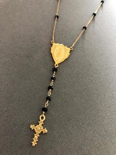 "This is a gorgeous rosary necklace with Onyx gemstone on Goldfilled chain and clasp. Necklace is 16\" with 2\" extender with 18k gold filled Miraculous Mary medallion hangs at center with 2\" drop. This special Necklace will arrive to you or someone special in a gift box." Spiritual Lariat Necklace With Adjustable Chain, Spiritual Long Lariat Necklace Gift, Spiritual Style Lariat Necklace As Gift, Gold Spiritual Lariat Necklace, Gold Single Strand Lariat Necklace Gift, Gold Single Strand Lariat Necklace As Gift, Gold Single Strand Drop Necklace As Gift, Adjustable Crucifix Necklace For Gift, Spiritual Black Lariat Necklace